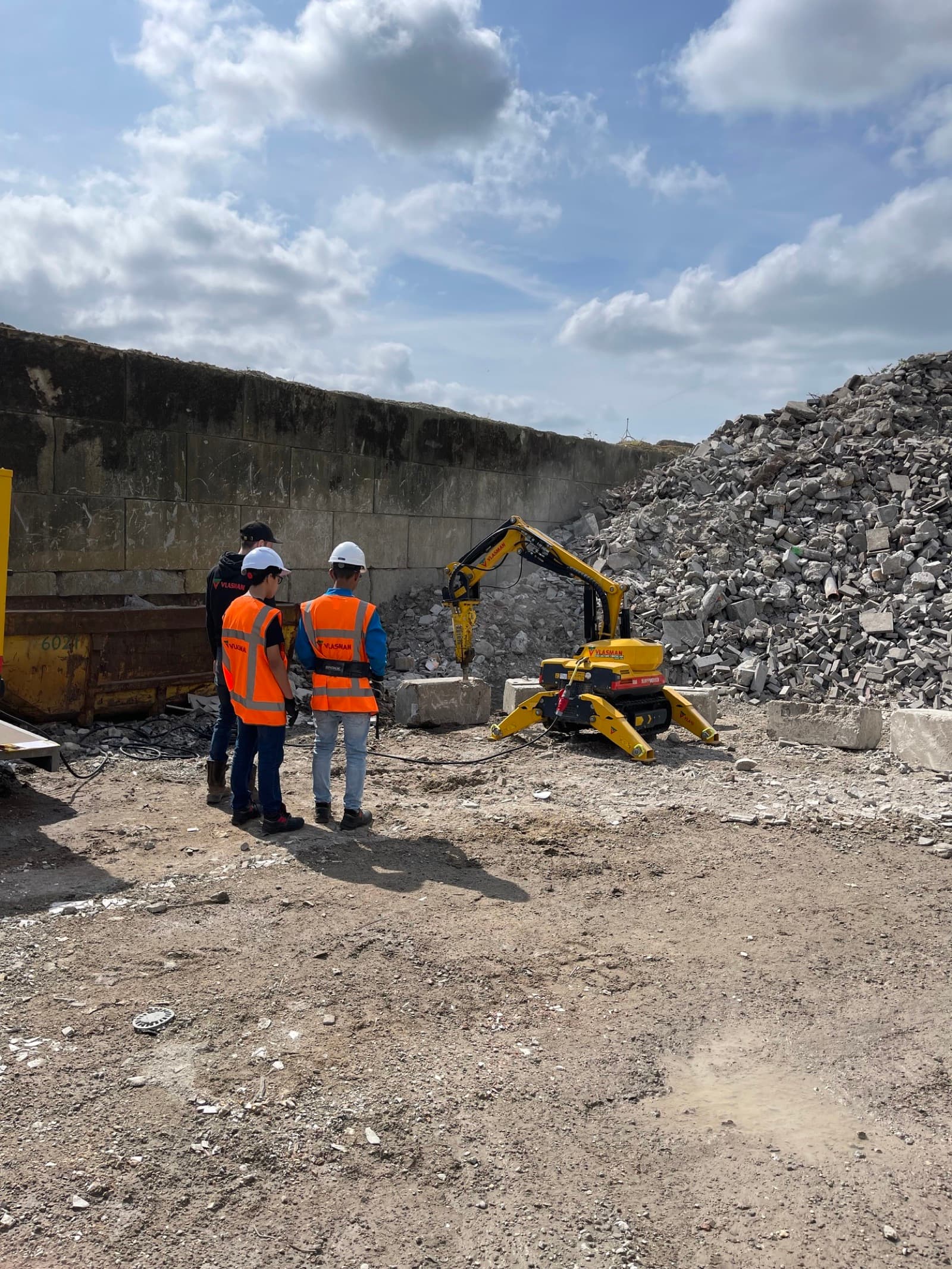 Vlasman-slooprobot breekt beton terwijl medewerkers toekijken